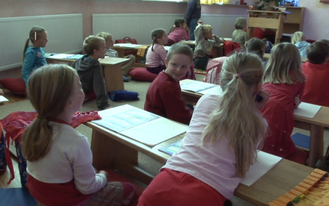 In roten Farben gekleidete Kinder in einer bayerischen Waldorfschule.